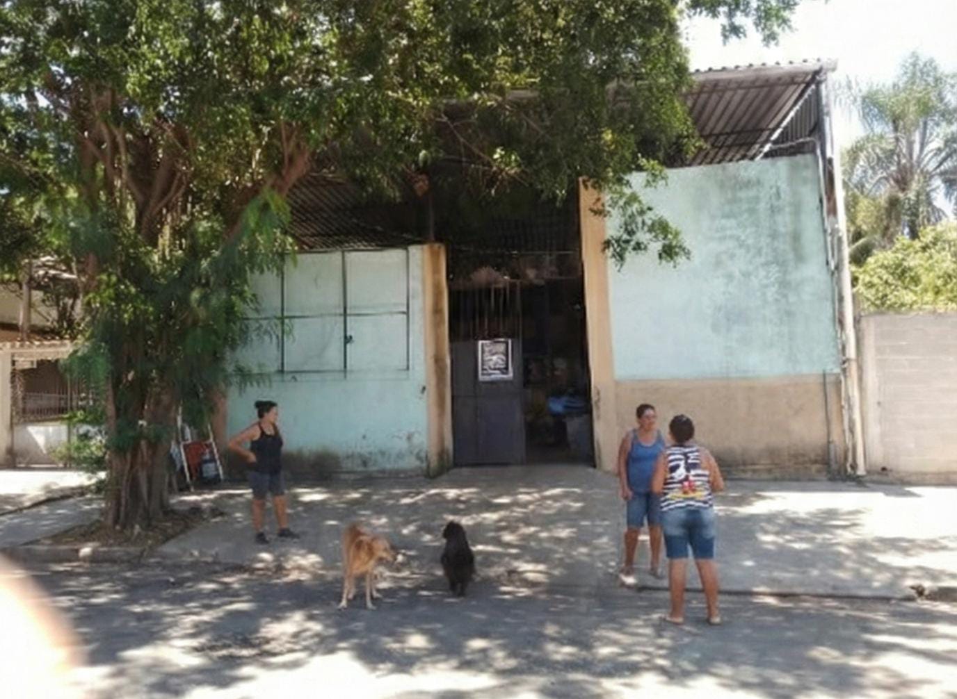 Fachada da sede da Coopquitungo, com cooperadas na calçada em frente ao portão